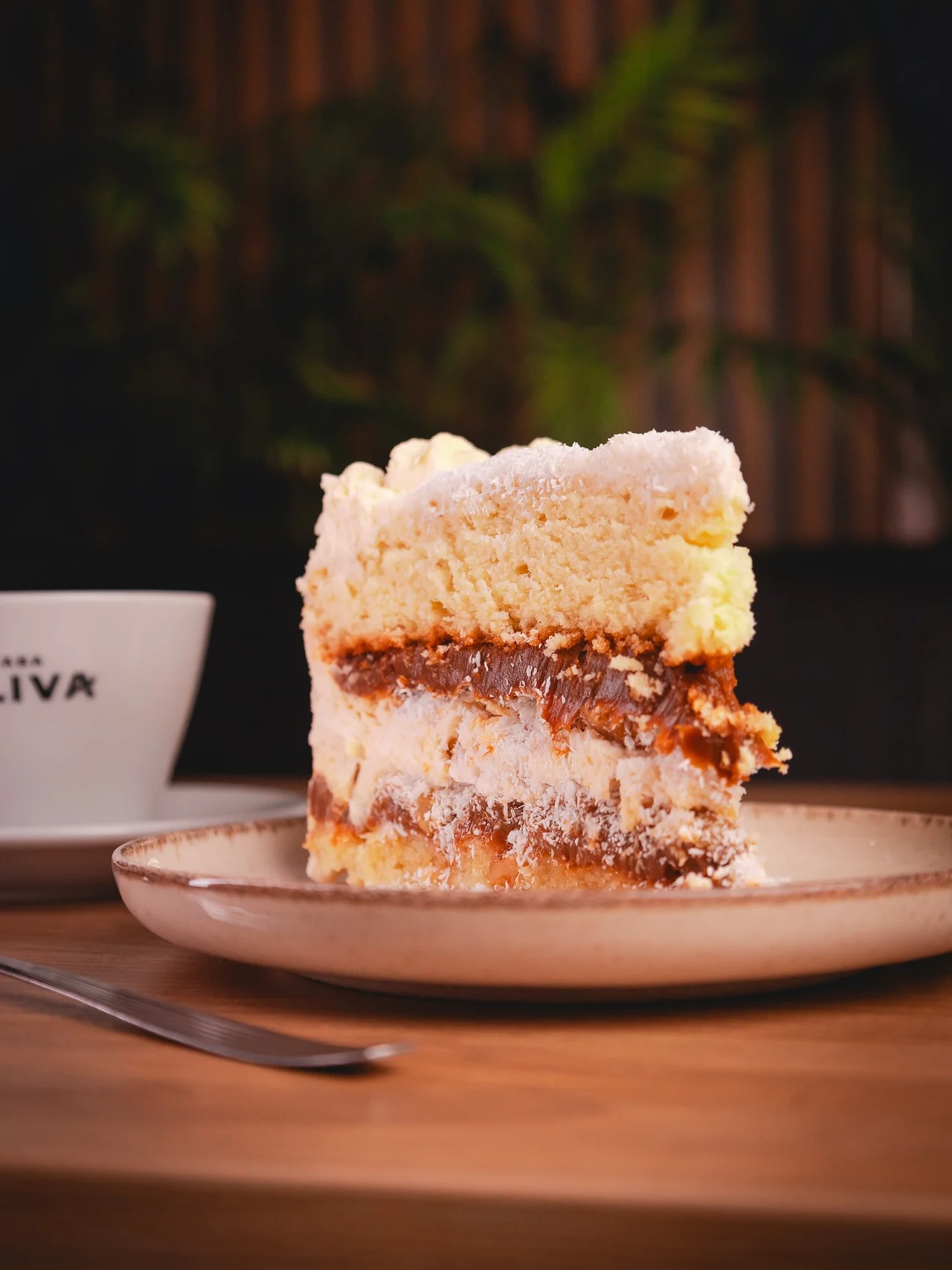 Una porción de torta Balcarce con café en una taza de Oliva