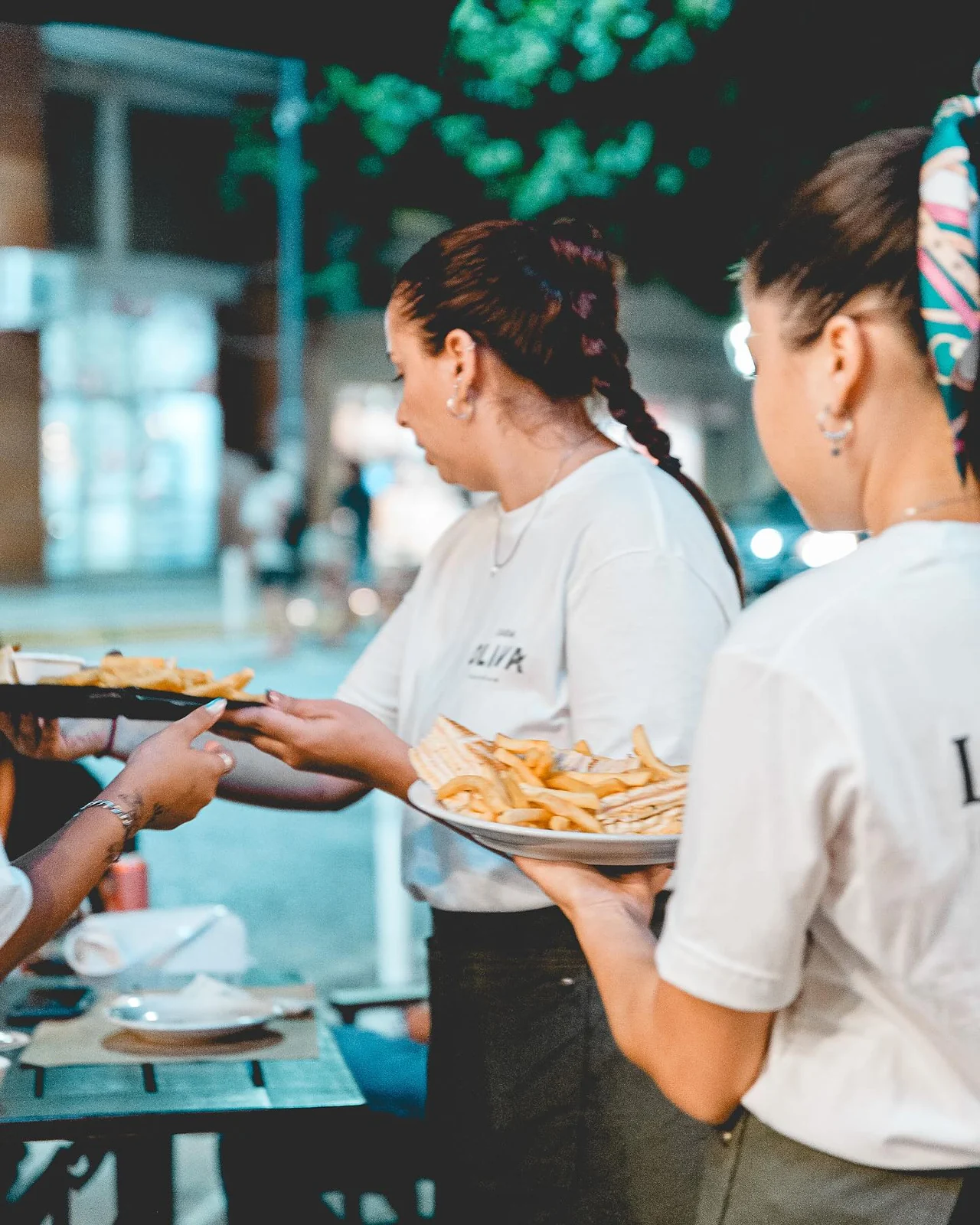 El equipo de Oliva llevando platos a una mesa del restaurante